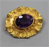 A late Victorian ornate yellow metal and amethyst set oval brooch, 40mm                                                                