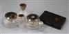 Four silver and tortoiseshell mounted glass toilet jars, a silver mounted scent bottle and a tortoiseshell vanity box.                 