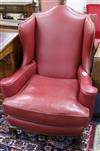 A pair of 1920's burgundy leather wing armchairs, on ball and claw feet                                                                