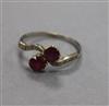 An early 20th century white metal, two stone ruby crossover ring, with diamond set shoulders, size O.                                  