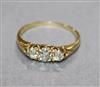 An early 20th century yellow metal and three stone diamond ring, size O.                                                               