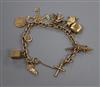 A 9ct gold charm bracelet hung with seven assorted charms including 9ct gold.                                                          