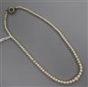 An early 20th century single strand graduated cultured pearl necklace, with green cabochon set clasp, approx 45cm.                     