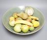 A collection of vintage Penkridge ceramic fruit including a pomegranate, melon, two bananas, limes, lemon, pear etc (18 items) in a green ceramic bowl, 42cm diameter                                                       