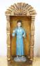 A painted saint with a blue robe and gilt metal halo, standing in an ornate carved niche, 57cm                                                                                                                              