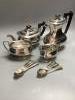 A four piece plated tea set and plated teaspoons.                                                                                                                                                                           