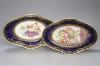 A pair of Coalport oval dishes, painted with fruit under blue border, c.1810, length 29cm                                                                                                                                   