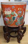 A Chinese coral ground famille rose jardiniere, wood stand Total height 60cm                                                           