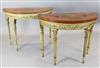 A near pair of Edwardian painted satinwood and giltwood demi-lune console tables, W.3ft 3in. D.1ft 5in. H.2ft 6in.                     