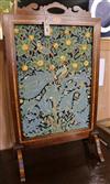 An Edwardian inlaid mahogany firescreen inset woolwork panel in a William Morris-style bird and fruit design                           