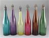 Six assorted coloured glass wine bottles with vineous collars and stoppers,                                                            