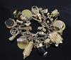 An early 20th century 18ct gold charm bracelet, hung with twenty seven assorted mainly 9ct gold charms,                                