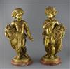 A pair of ormolu figures of putti holding flowers and a sickle, height 20.5in. diameter of bases 8in.                                  