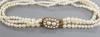 An Edwardian triple strand seed pearl bracelet, with yellow metal and seed pearl set clasp                                                                                                                                  