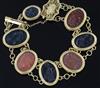 A late Victorian style gold and Intaglio hardstone bracelet, with filigree clasp and safety chain, gross 48.9 grams.                   