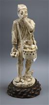 A Meiji carved ivory figure of a man inspecting bird eggs, a sectional carving                                                         