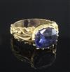 An antique yellow metal ring set with an oval sapphire in scroll-carved and pierced mount, size O.                                     