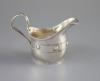 An Edwardian Arts & Crafts planished silver cream jug by John Gatecliff                                                                                                                                                     