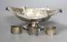 An Edwardian repousse silver pedestal bowl, Sheffield, 1901, 28.5cm and three silver napkin rings, 12.5oz.                                                                                                                  