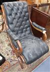 A mahogany open armchair upholstered in buttoned black leather                                                                         