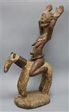 A Yoruba patinated wood group of a woman riding a horse height 65cm                                                                    