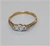 An 18ct gold, platinum and three stone illusion set diamond ring, size P.                                                              