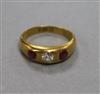 An 18ct gold and three stone gypsy set ruby and diamond ring, size K.                                                                  