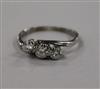 A 1940's white metal and three stone diamond crossover ring, size L.                                                                   