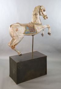 A 19th century, probably American, painted wood carousel horse, L.3ft 5in. H.3ft 7in. Overall H. when on stand 5ft 9in.                