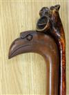 An unusual Toucan-head hardwood walking stick and a grotesque head walking stick                                                       