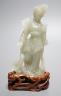 A Chinese celadon jade figure of a lady wood stand, 13 cms high.                                                                                                                                                            