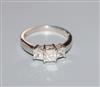 A platinum and graduated three stone princess cut diamond ring, size O.                                                                