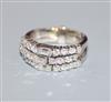 A white metal, baguette and round cut diamond set triple band ring, size                                                               