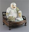 A Chinese famille rose seated figure of Budai, Republic period, H. 27cm, excluding hongmu 'throne' stand                               