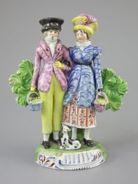 A Staffordshire pearlware group of a Dandy and Dandizette with seated dog, c.1820-30, 18cm high                                        