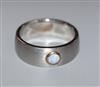 A modern brushed steel? band with single stone collet set white opal, size Z.                                                          