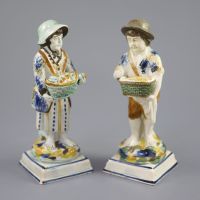 A pair of Prattware figures of fruit and biscuit street vendors, c.1790-1800, 17.5cm high                                              