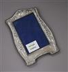 An Art Nouveau silver mounted photograph frame, with a floral embossed border, Birmingham, 1909, 20.3cm.                               