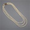 A triple strand cultured pearl necklace with engraved yellow metal clasp, 50cm.                                                        