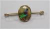 An early 20th century yellow metal bar brooch with oval glazed panel decorated with a bird, 50mm.                                      