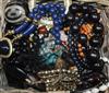 A group of assorted costume jewellery including necklaces and beads and a pair of opera glasses.                                       