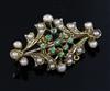 An Edwardian gold, split pearl and demantoid garnet set brooch, 32mm.                                                                  