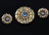 A 9ct gold, blue zircon and diamond set circular pendant brooch, and a similar pair of 9ct gold and blue zircon and earrings           