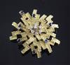 A 1970's? textured 18ct gold, diamond and sapphire set stylised starburst brooch, 43mm.                                                