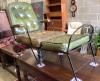 A 19th century wrought iron campaign chair with buttoned green leather seat and back                                                                                                                                        