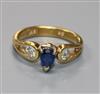 A modern 18ct gold, sapphire and diamond three stone ring, size J.                                                                     