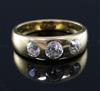 An 18ct gold and gypsy set three stone diamond ring, size N.                                                                           