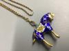 An enamelled gilt horse pendant on an unmarked yellow metal guard chain                                                                                                                                                     