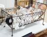 3 Armand Marseille bisque head dolls with sleeping eyes and 4 others in a wrought iron dolls crib 80cm                                                                                                                      