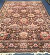 A Persian-style aubergine ground carpet, all over woven with large stylised flowerheads, 350 x 249cm (worn in places)                  